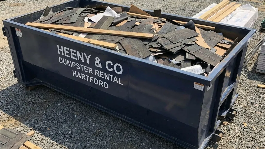 Storm and flood cleanup in Hartford, Connecticut — container taking soaked basement contents and storm limb wood